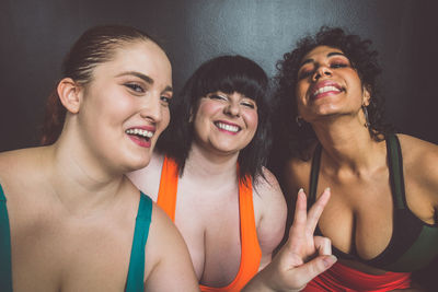 Smiling women standing against wall