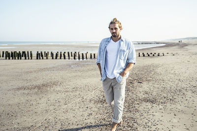 Portrait of young man standing on beach