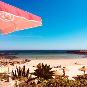 Scenic view of beach against clear blue sky