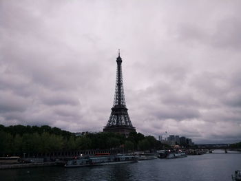 Tower in city against cloudy sky