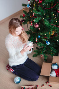 Full length of girl decorating christmas tree