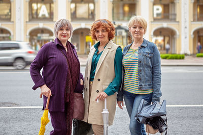 Portrait of smiling women standing in city