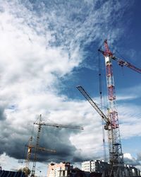Low angle view of cranes against sky