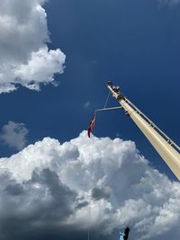 Low angle view of people working against blue sky