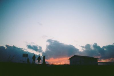 Houses against sky at sunset