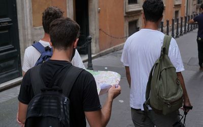 Rear view of people standing on street against buildings