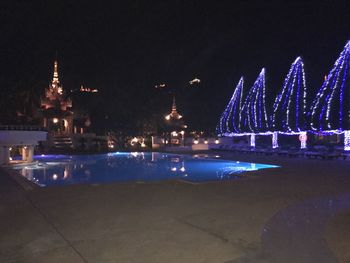 Illuminated city against sky at night