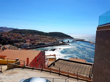 High angle view of townscape by sea against clear sky