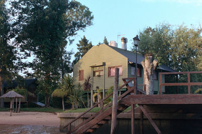 Houses by trees against sky