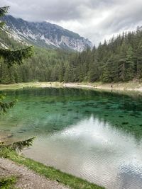 Scenic view of lake by mountains against sky