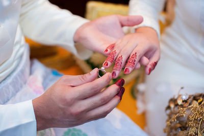 Midsection of couple holding hands