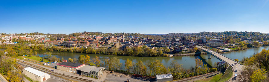 Panoramic view of river and buildings against clear blue sky