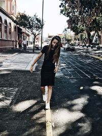 Woman with umbrella on street in city