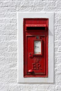 Close-up of red mailbox on wall