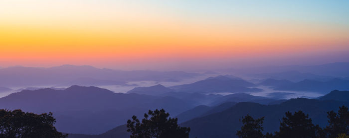 Scenic view of silhouette mountains against sky at sunset