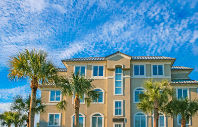 Palm trees and buildings against blue sky