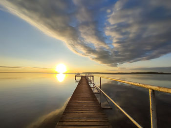 Pier over sea against sky during sunset