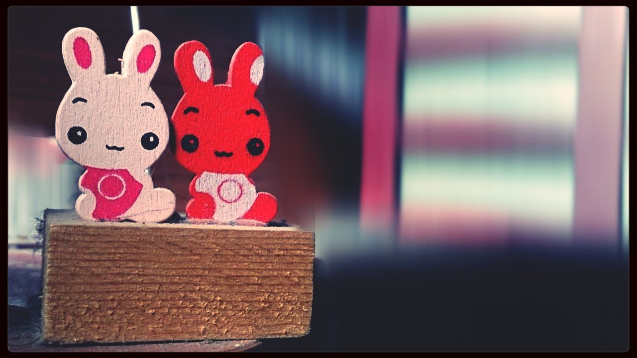 indoors, transfer print, auto post production filter, red, still life, close-up, table, wood - material, toy, home interior, pink color, no people, art and craft, stuffed toy, wall - building feature, animal representation, multi colored, creativity, sweet food, variation