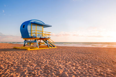 Lifeguard hut on beach against sky