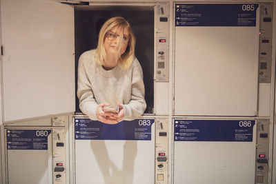 Portrait of young woman lying down in locker