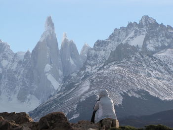 Rear view of person on snowcapped mountains against clear sky