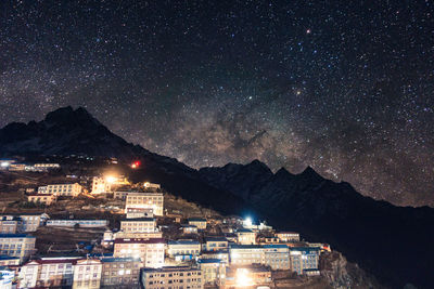 Illuminated cityscape against sky at night