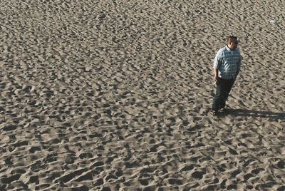 Full length of man standing on sand at beach