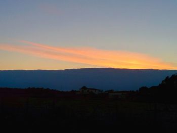 Scenic view of silhouette mountains against sky at sunset