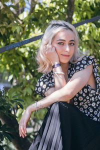 Portrait of beautiful young woman against tree