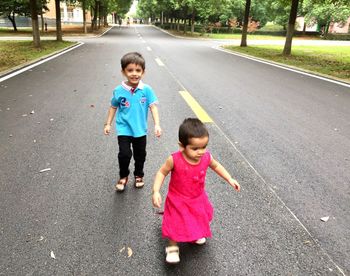 Siblings standing on road