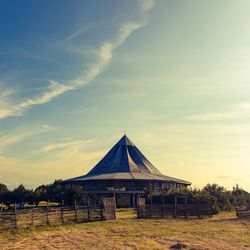 Built structure on field against sky at sunset