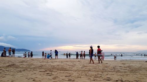 People at beach against sky