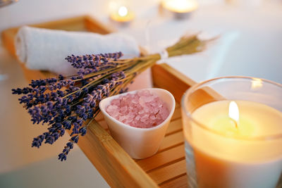 Spiritual aura cleansing ritual bath for full moon ritual. candles, aroma salt and lavender on tub 