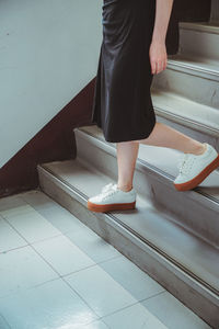 Low section of woman standing on staircase