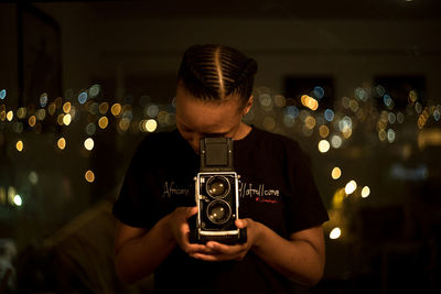 Man photographing illuminated camera