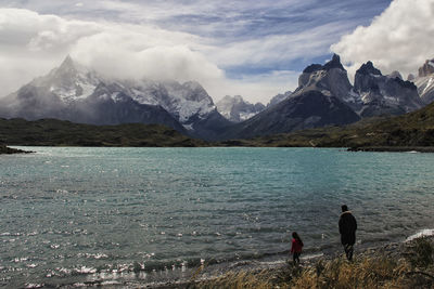 Rear view of people on mountain against sky