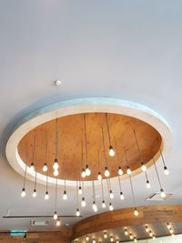 Low angle view of illuminated pendant lights hanging from ceiling