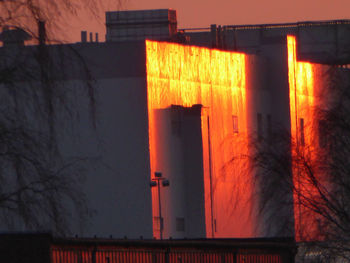 Scenic view of illuminated building against sky at sunset