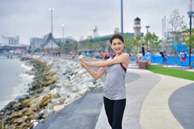 Portrait of smiling young woman standing in city