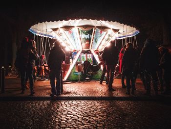 People at amusement park ride at night