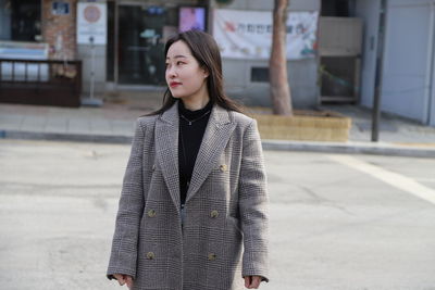 Portrait of young woman standing in city