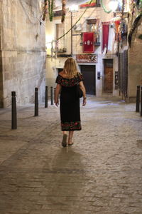 Rear view of woman walking on street in city