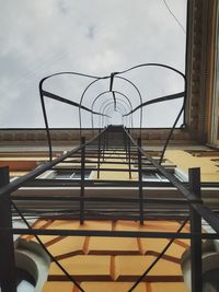 Low angle view of ladder by swimming pool against sky