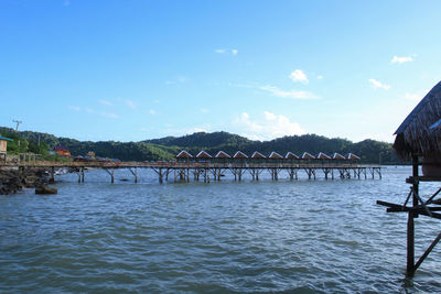 Bridge over sea against blue sky