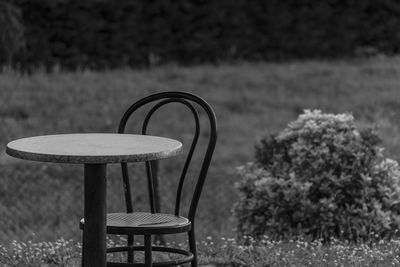 Empty chair and table on field
