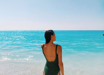 Rear view of woman looking at sea against sky