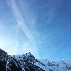 Low angle view of snowcapped mountains against sky