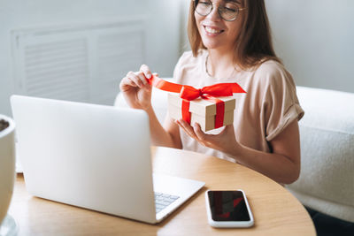 Young woman in glasses doing online shopping on a laptop at home