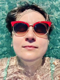 Portrait of woman wearing sunglasses swimming pool