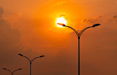 Low angle view of street light against orange sky